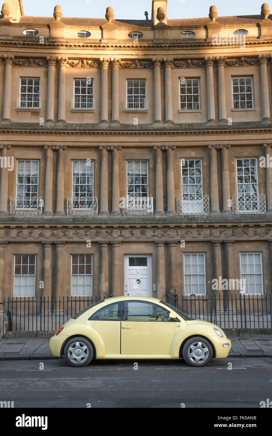 Yellow VW, view of a yellow Volkswagen beetle car parked in The Circus in the city of Bath, England, UK. Stock Photo