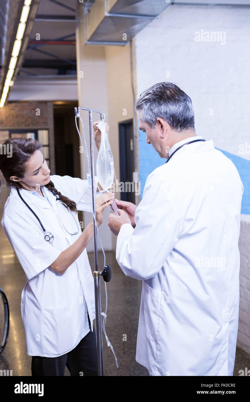 Doctors checking a saline drip Stock Photo Alamy