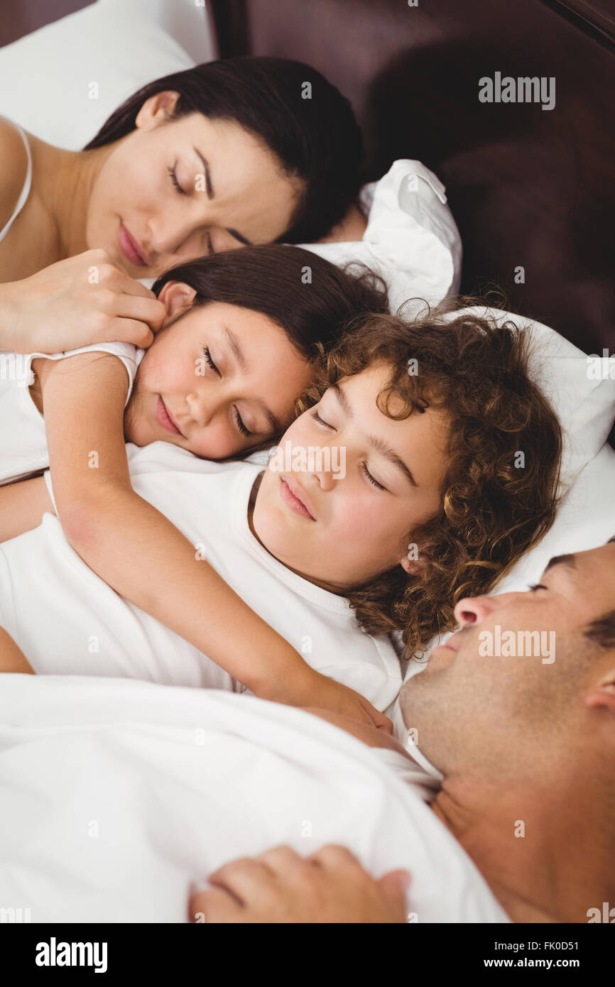 Children sleeping with parents on bed Stock Photo Alamy