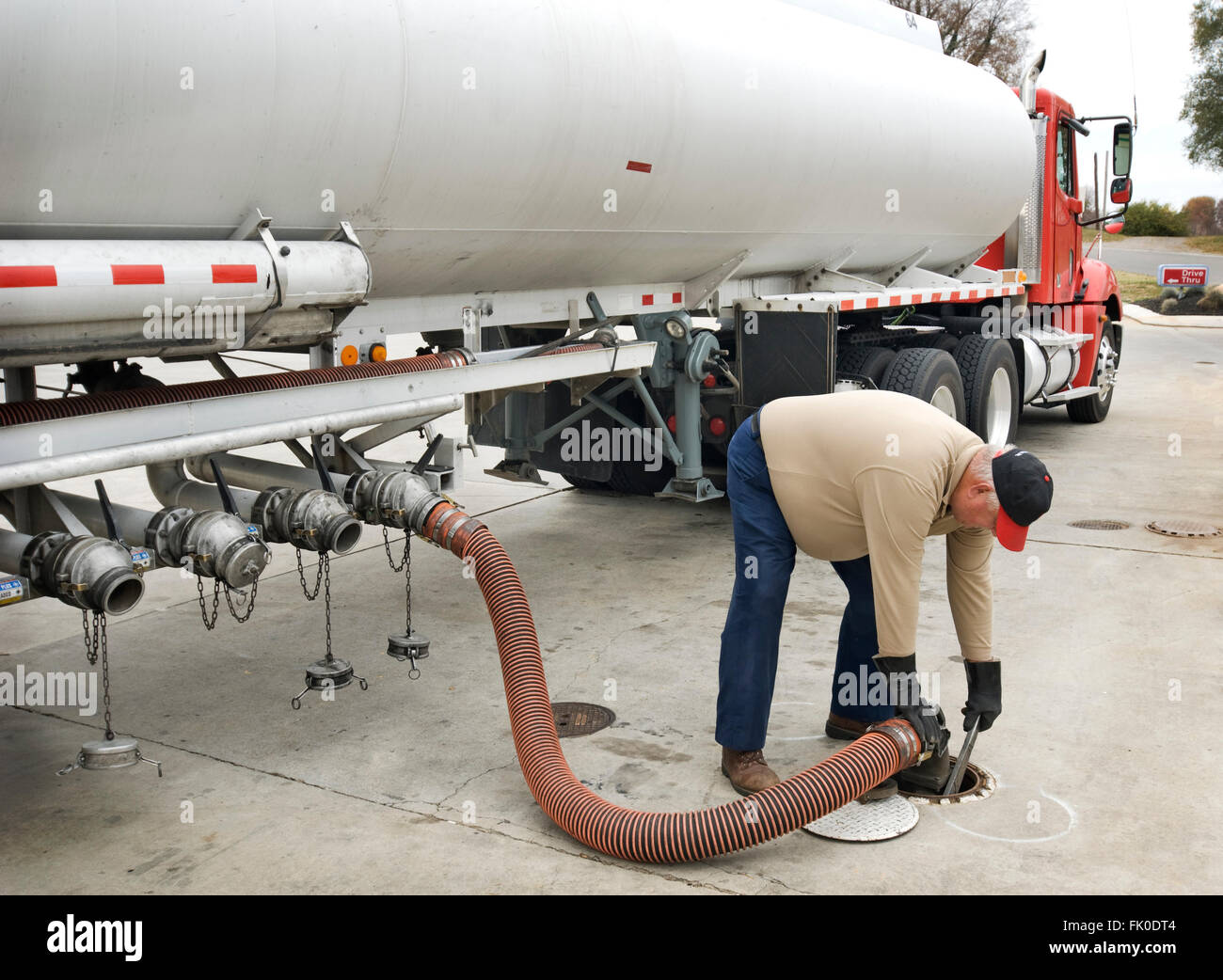 Fuel Delivery Operator Fills Underground Tank Stock Photo