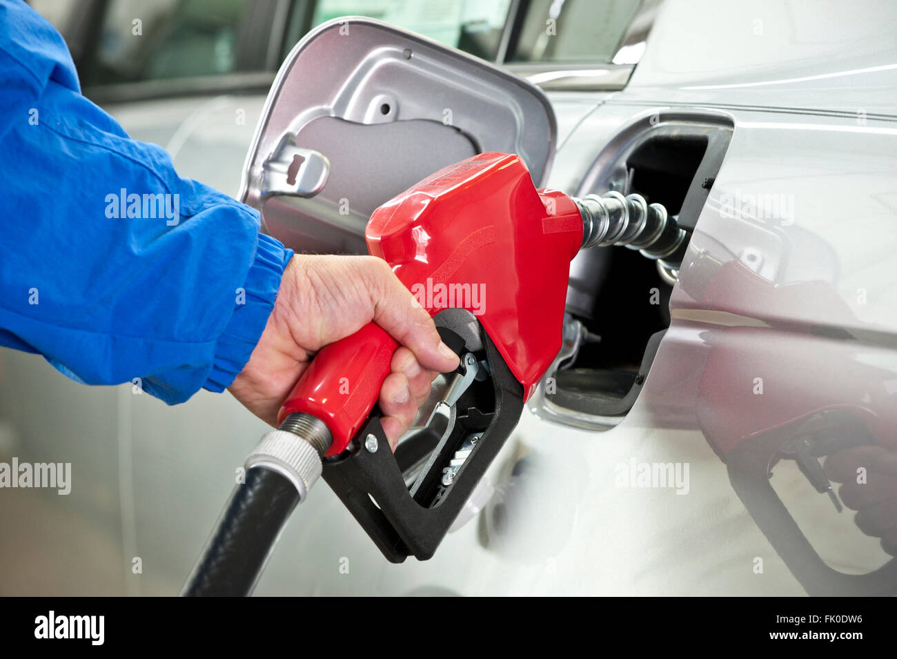 Hand Pumping Gasoline From Red Fuel Pump Nozzle Stock Photo