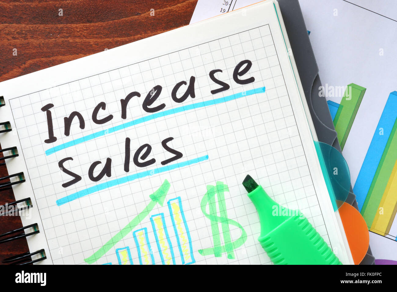 Increase sales concept  written in a notebook on a wooden table. Stock Photo