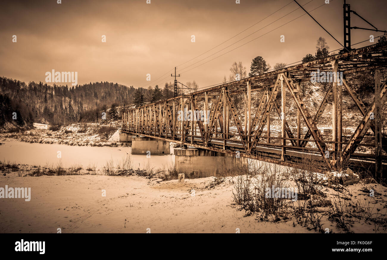 Steel railway flyover over frozen river in winter Stock Photo