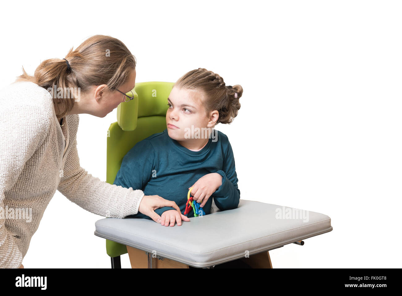 A disabled child in a wheelchair being cared for by a voluntary care worker Stock Photo