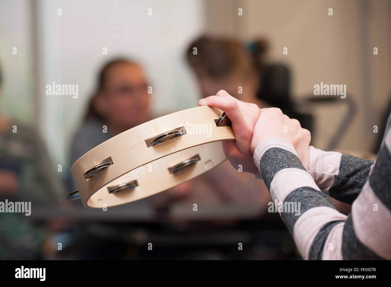 A disabled child in a group enjoying music therapy Stock Photo