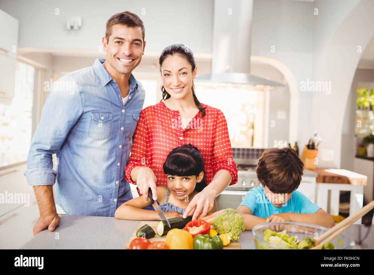 Happy woman preparing food with family Stock Photo