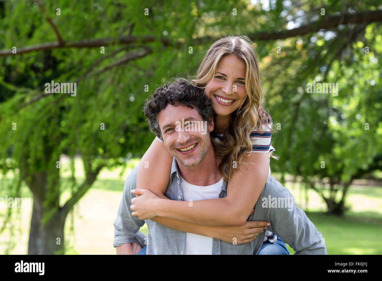 Husband giving a piggy-back to his wife Stock Photo