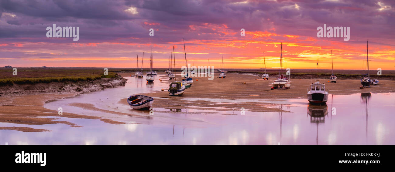 Boats on the sand banks in Wells harbor at sunrise. Stock Photo