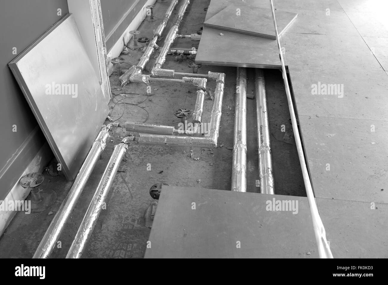 Heating pipework complete with environmentally friendly lagging fitted under the floor on a construction site. 4th March 2016 Stock Photo
