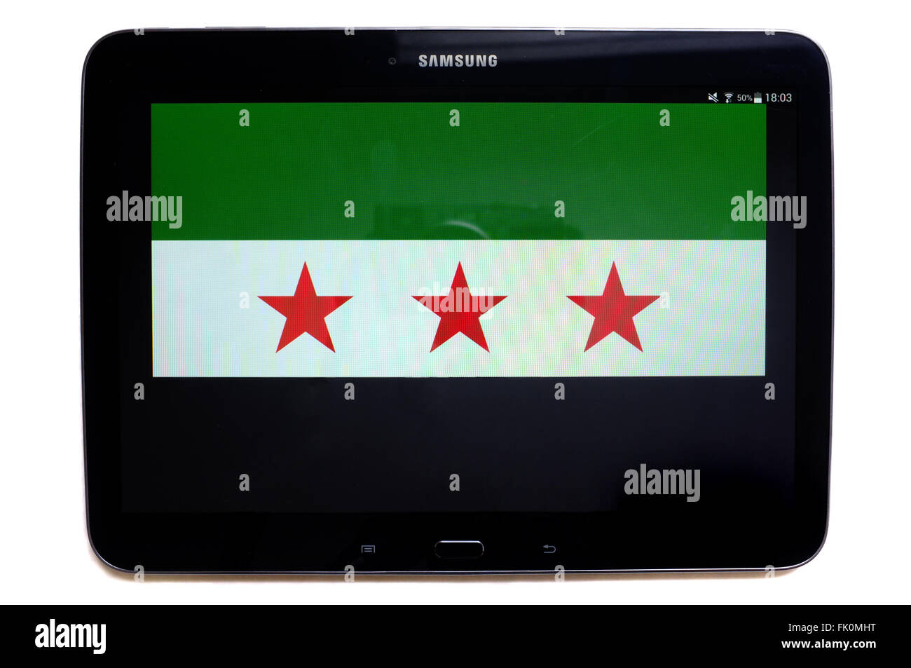 The Free Syrian flag displayed on the screen of tablet photographed against a white background. Stock Photo
