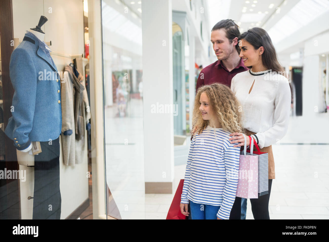 Happy family window shopping in mall Stock Photo