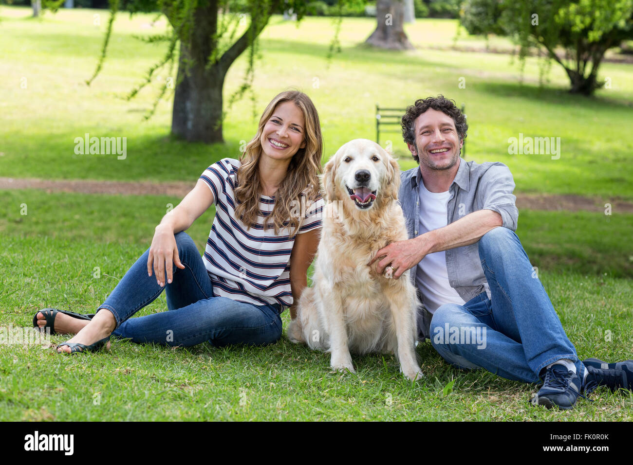 Couple with their dog in the park Stock Photo - Alamy