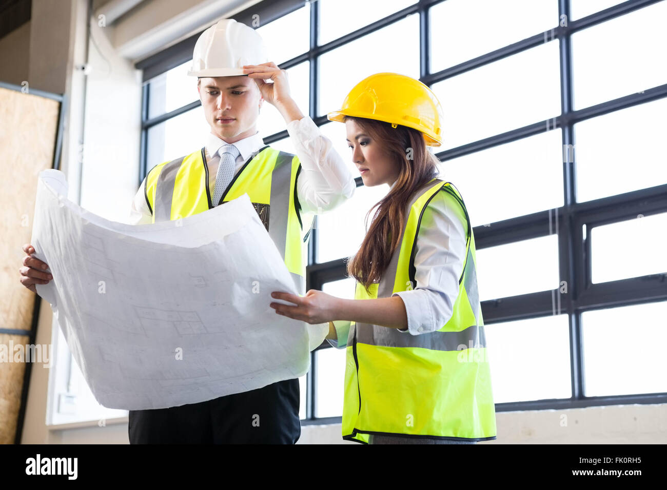 Architects looking at blueprint Stock Photo Alamy