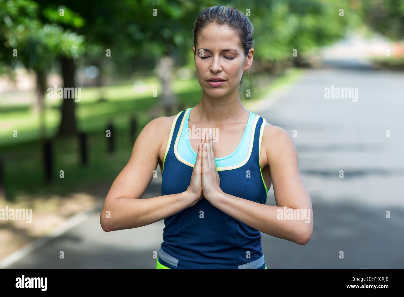 Sportswoman meditating with hands joined Stock Photo