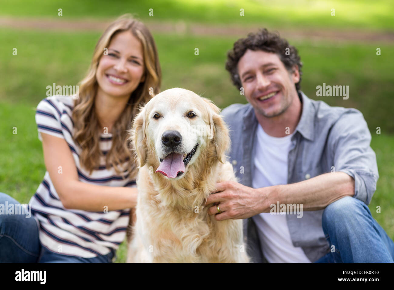 Couple with their dog in the park Stock Photo - Alamy