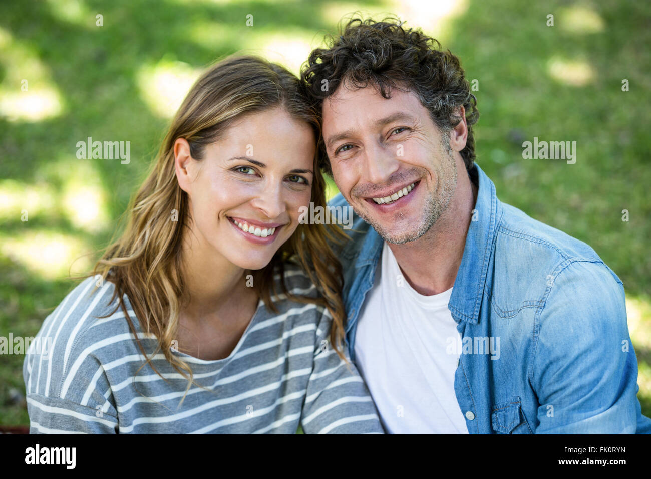 Couple sitting on the lawn Stock Photo - Alamy