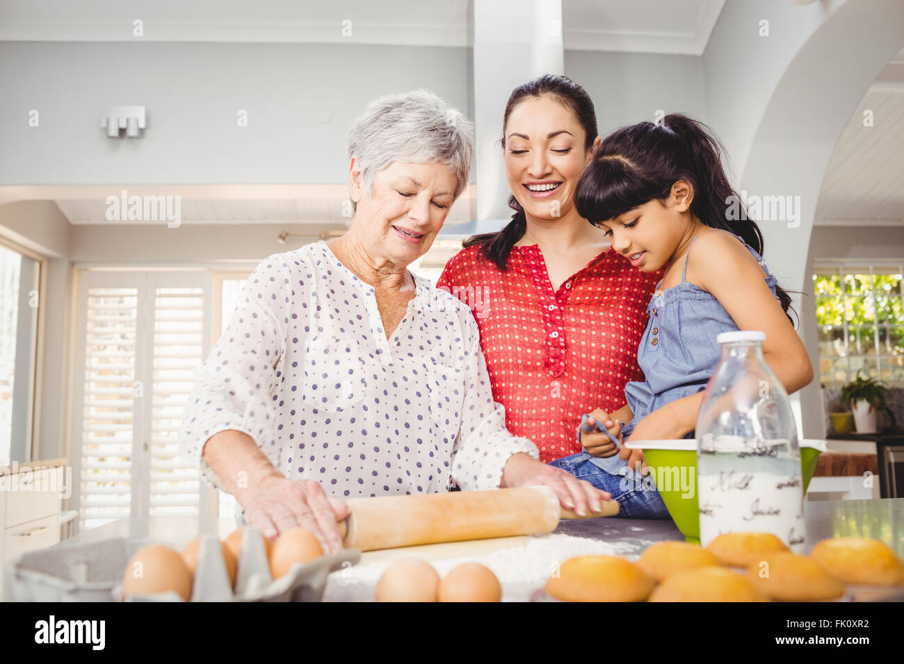 Senior woman preparing food with family Stock Photo