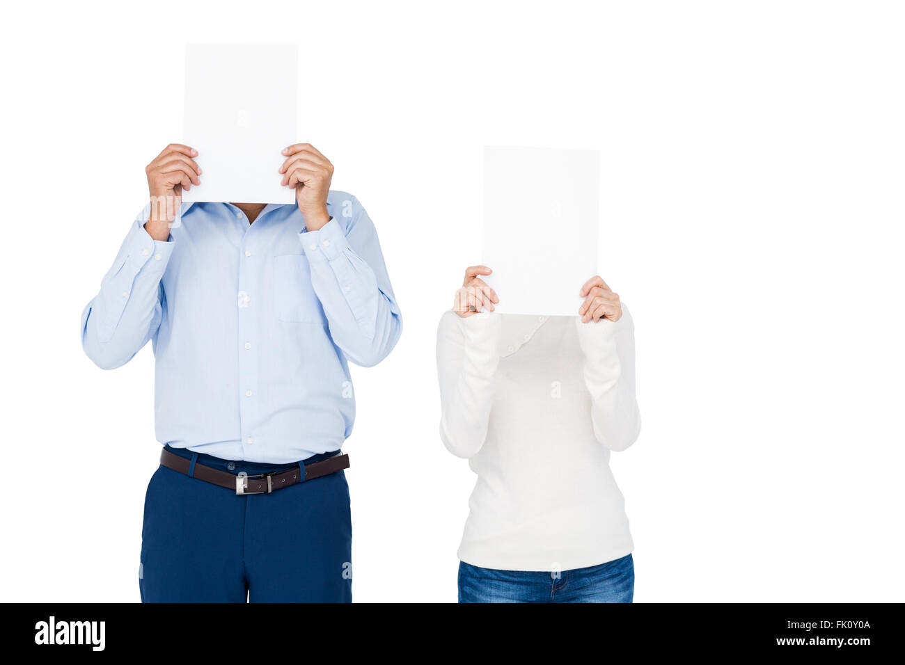 Couple covering face with paper Stock Photo