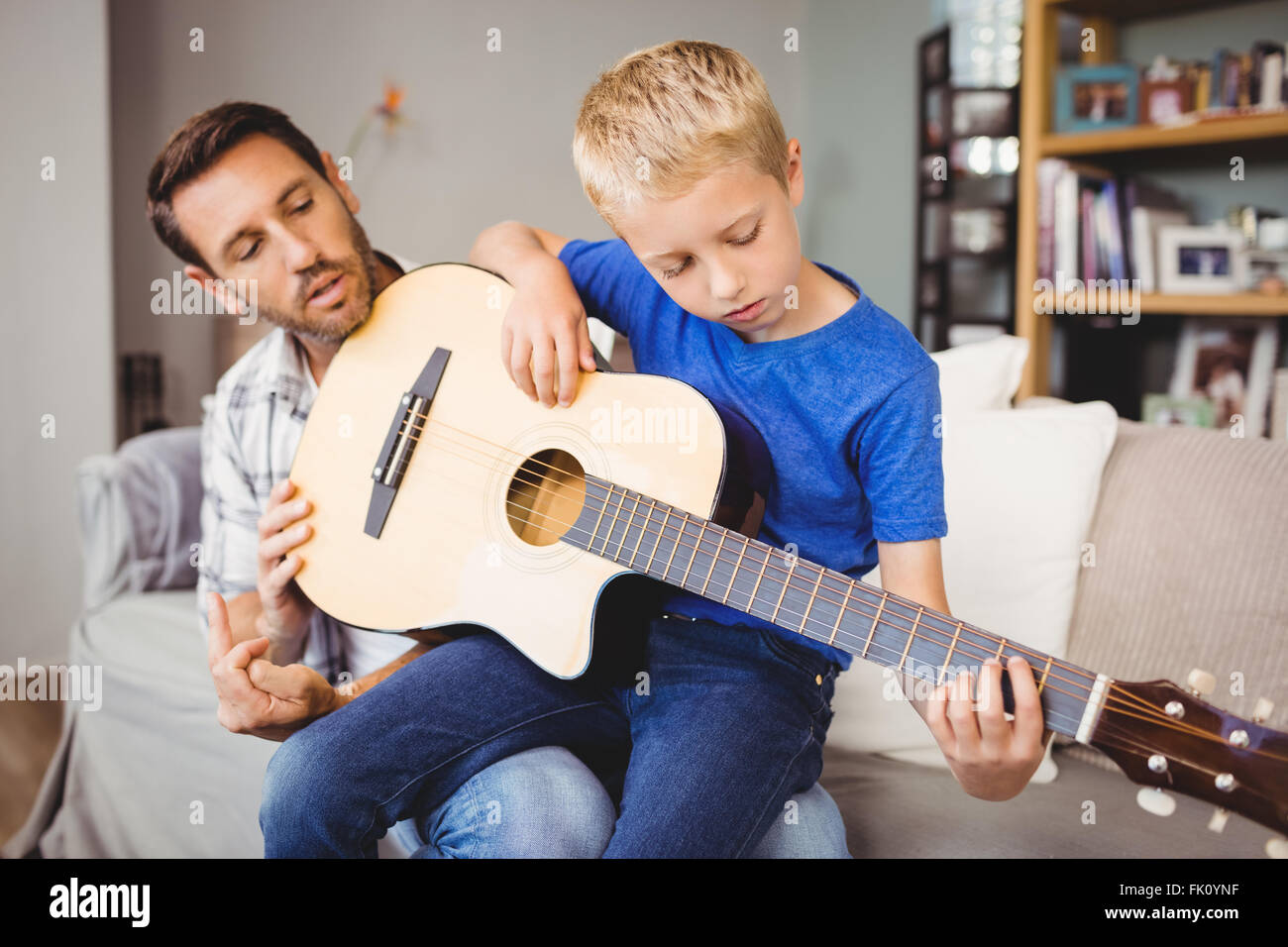 Русский папа учит сына. Гитарист отец и сын. Сын и отец гитара. Папа и сын играют на гитаре. Папа играет малышу на гитаре.