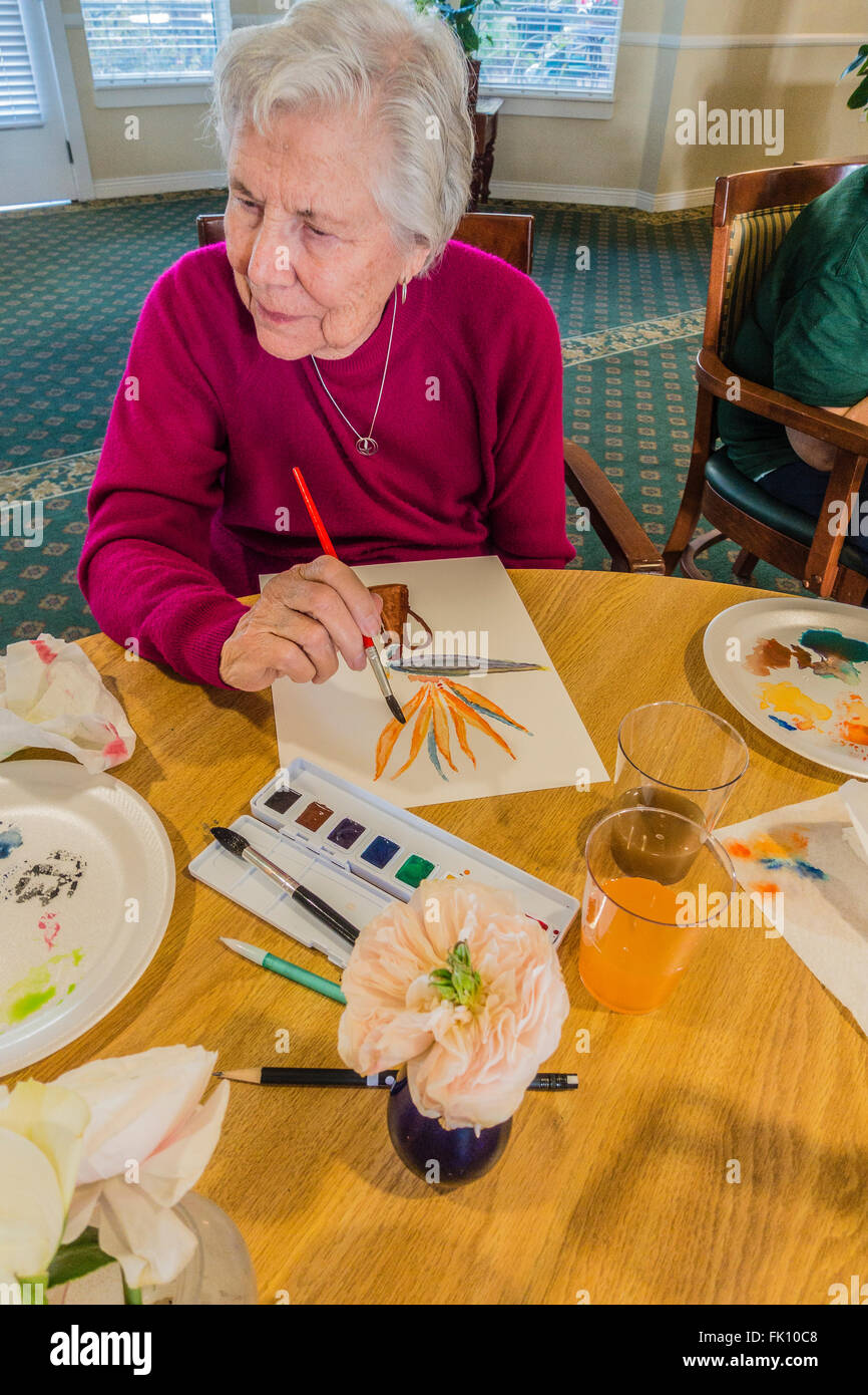 A Female Senior Citizen Paints In A Watercolor Class For Seniors