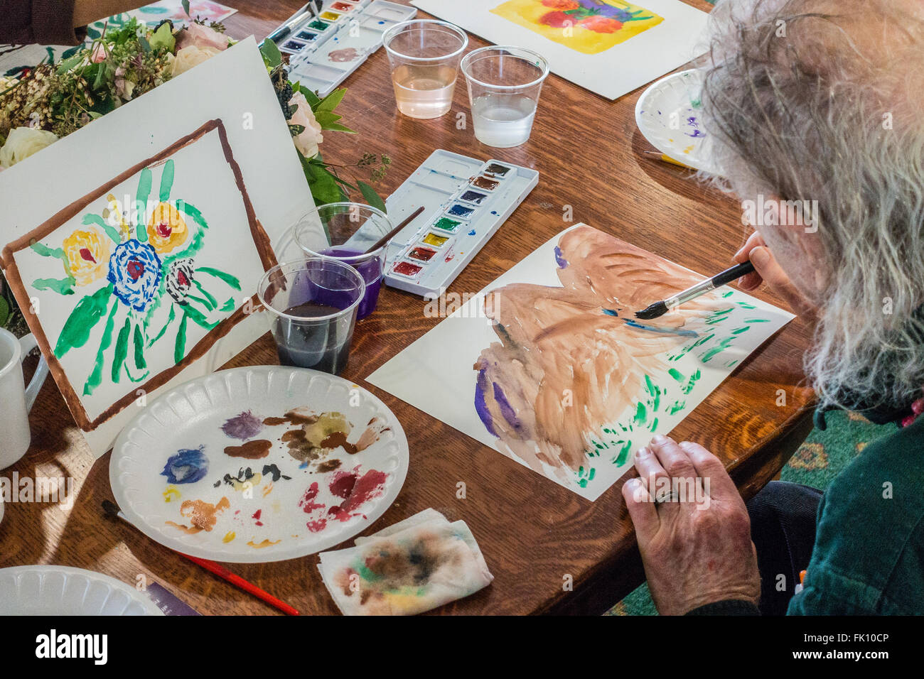 A Male Artist Paints In A Watercolor Class For Seniors At Garden