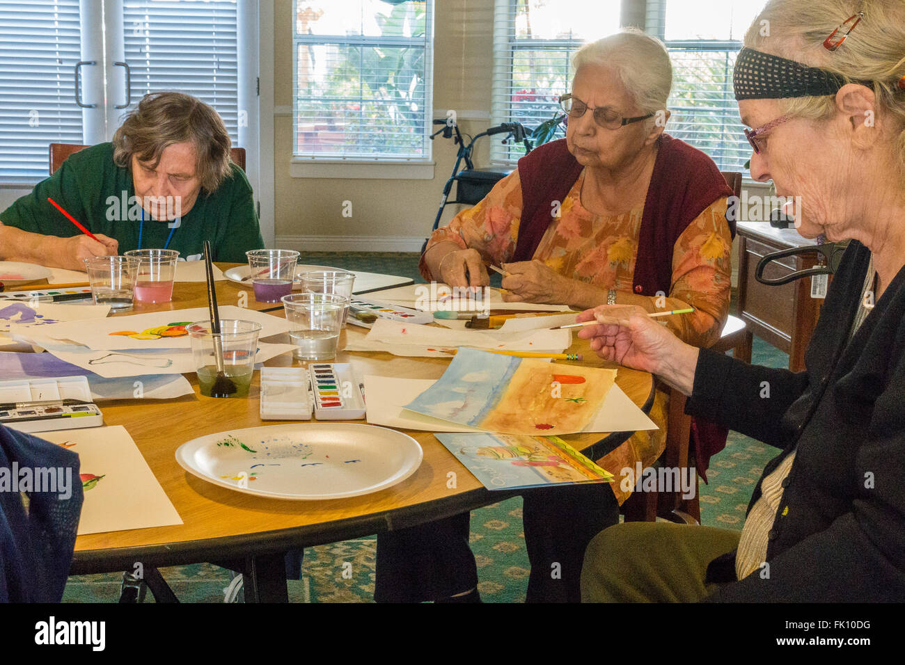 Female senior citizens paint in a watercolor class for seniors at