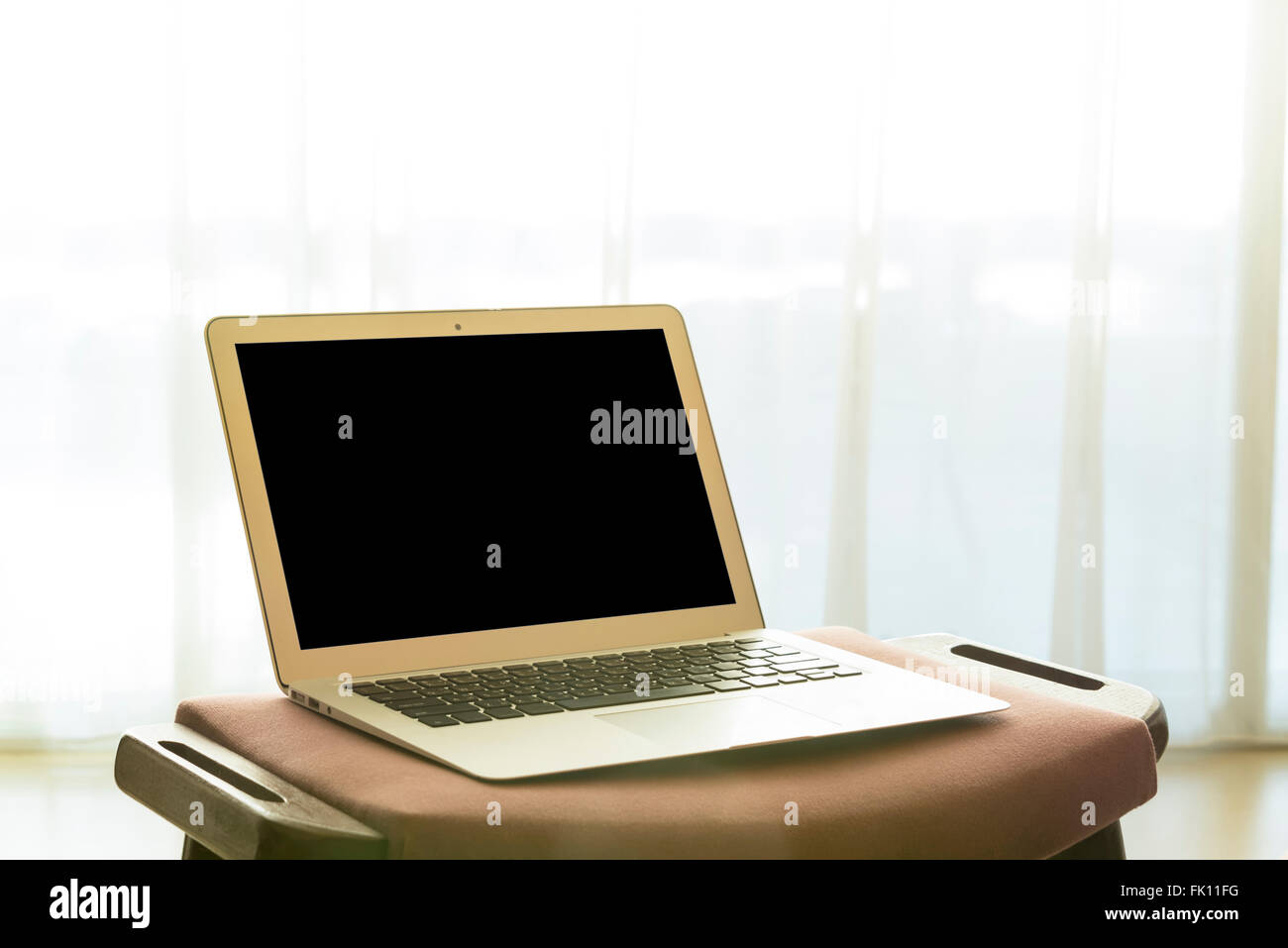 laptop computer and white curtains in bedroom. technology concept ...