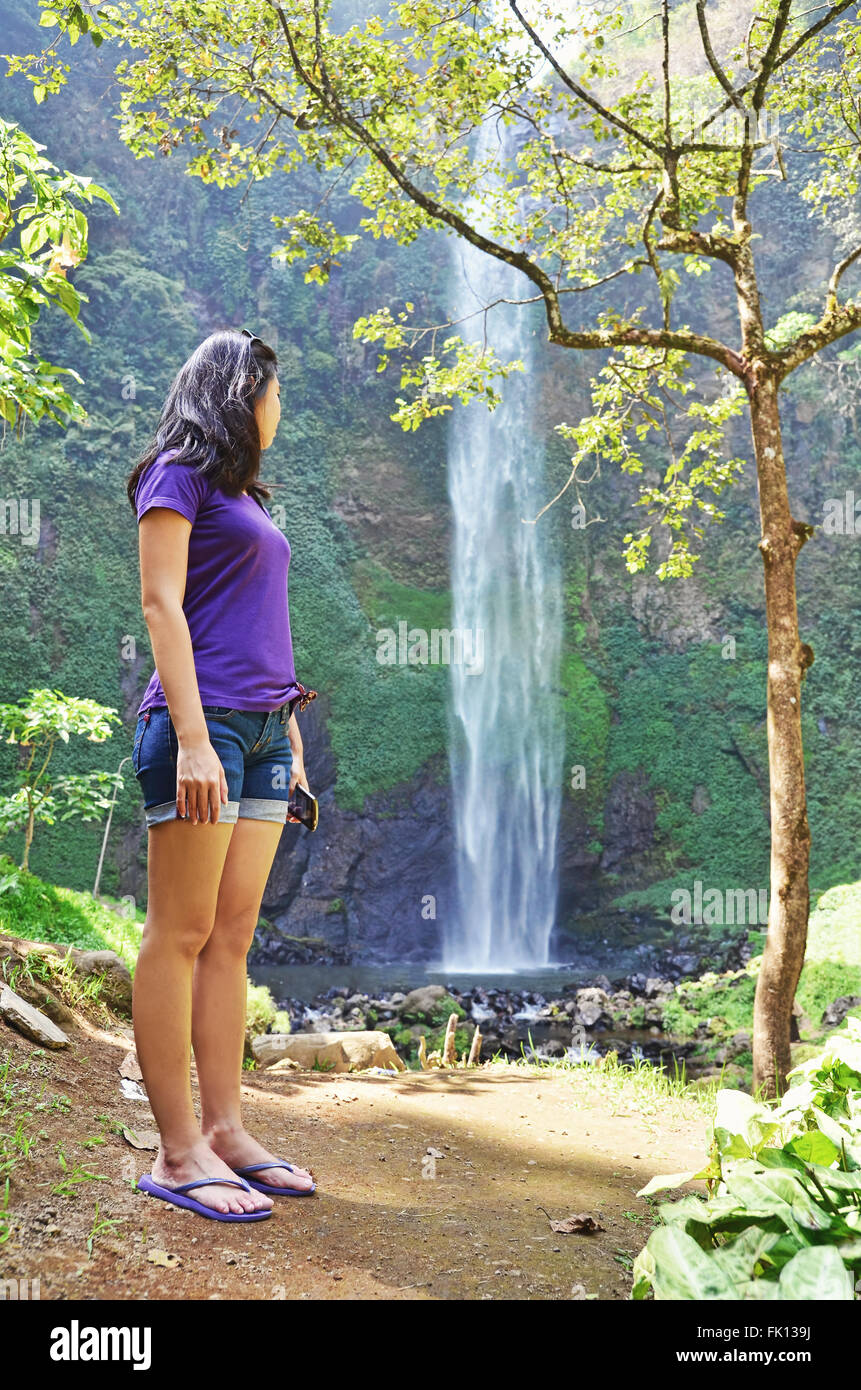 Girl standing next to a waterfall Stock Photo