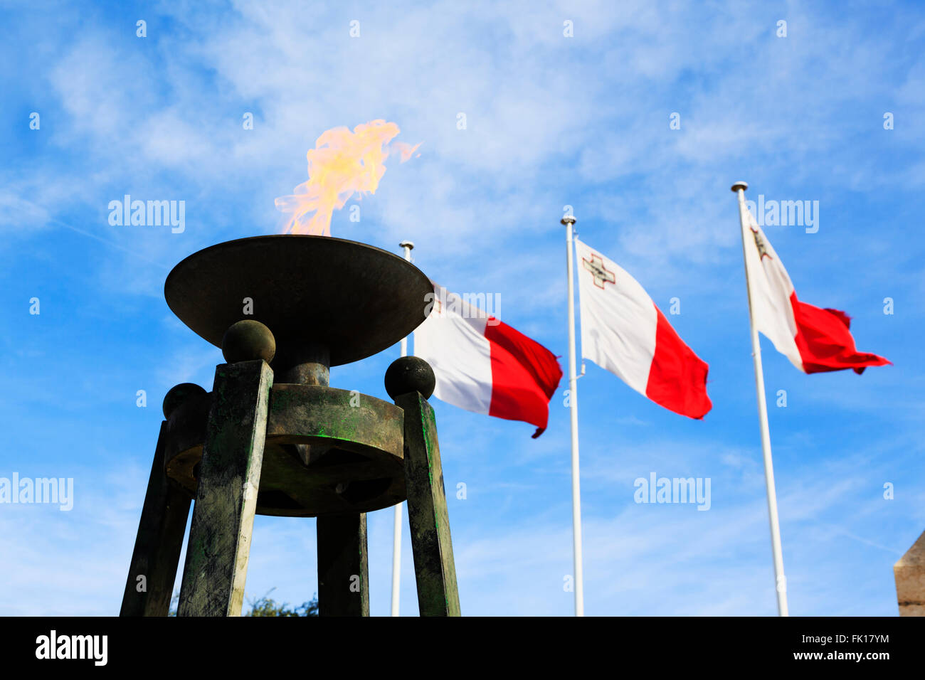 Eternal flame and Maltese flags at The War Memorial, Floriana, Valletta, Malta Stock Photo