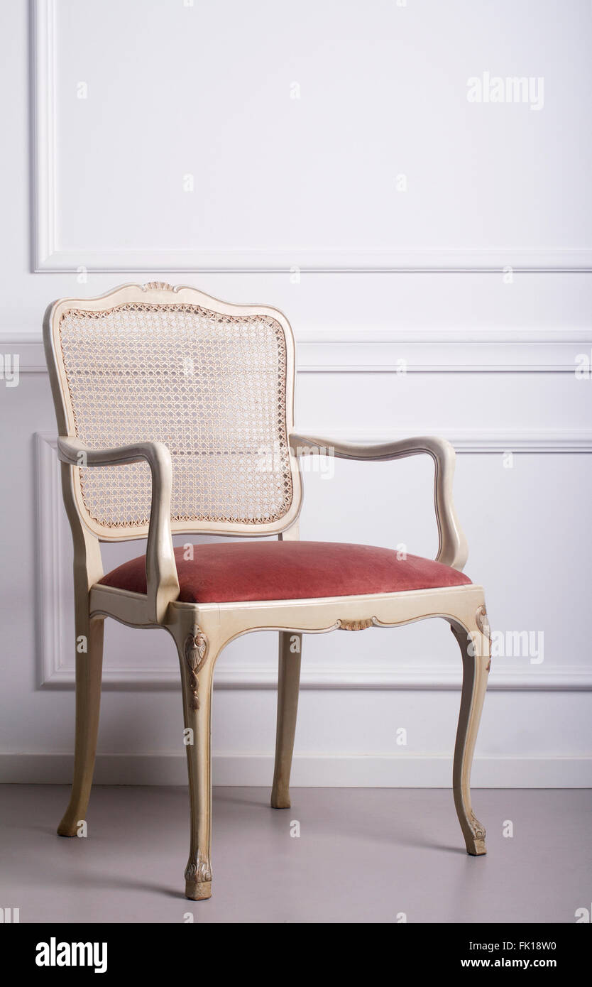 Vintage wooden chair against a white elegant interior wall Stock Photo