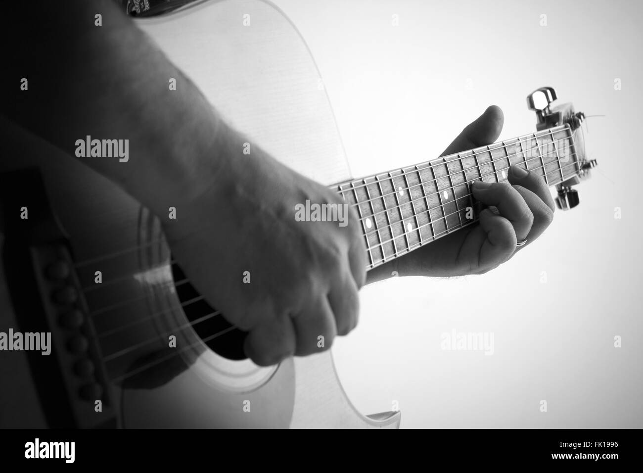 Black and white picture of a man playing the guitar, shallow depth of field Stock Photo