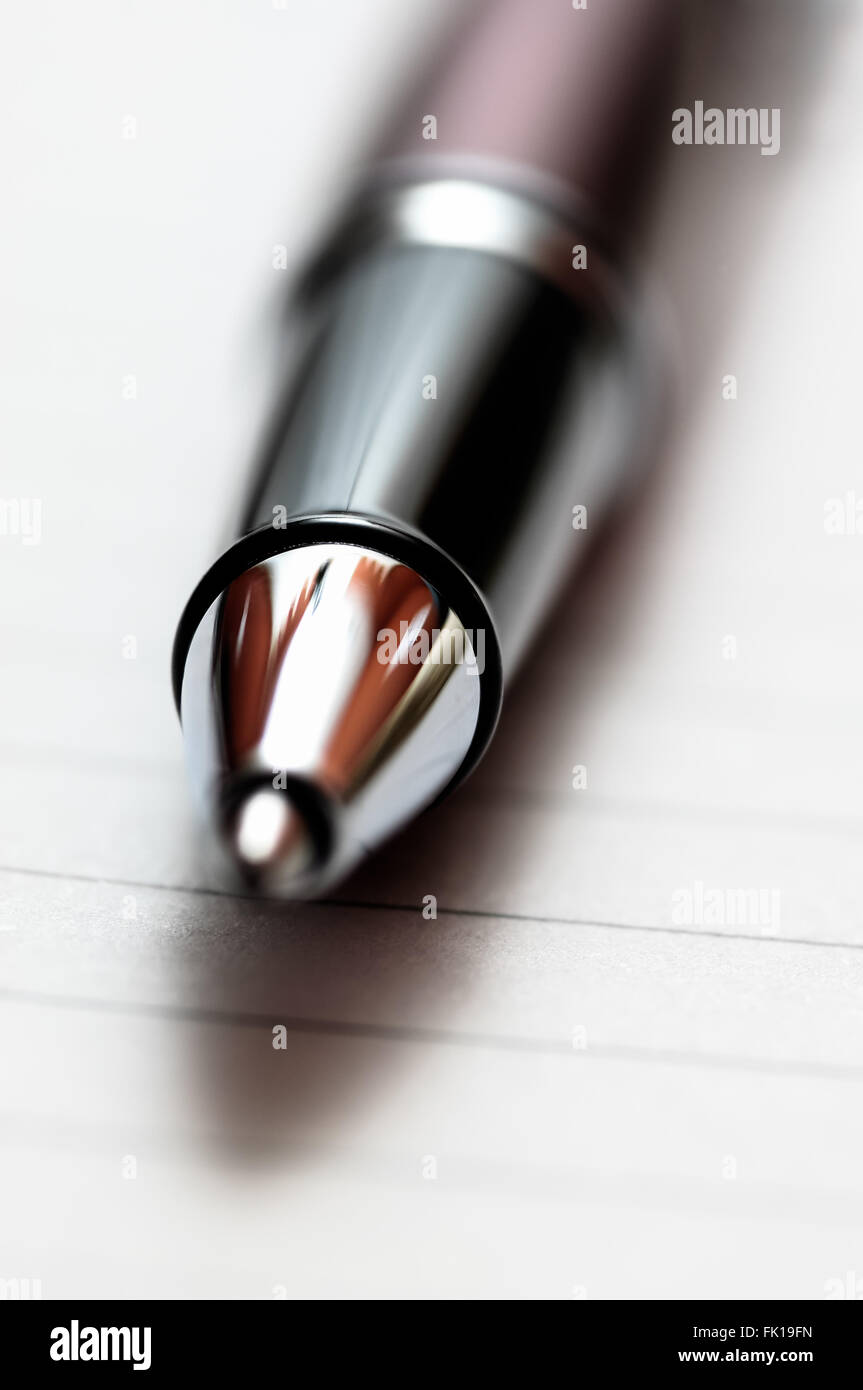 Picture a chrome, black, and red upscale executive ballpoint pen on lined notebook paper Stock Photo