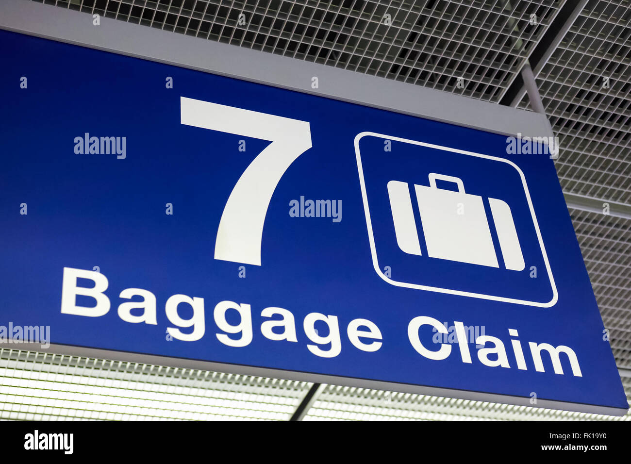 A blue airport baggage claim sign hanging from the ceiling Stock Photo