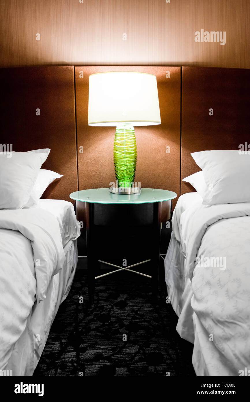 Modern hotel room with a lamp in between two beds Stock Photo