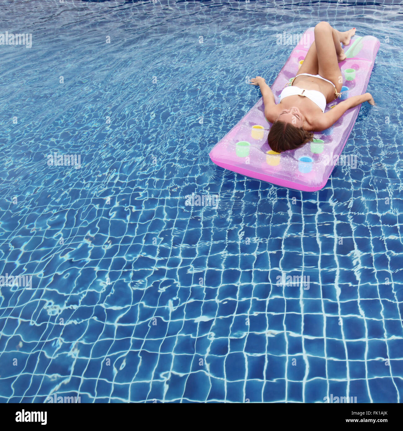 Woman relaxing in a pool floating on water bed Stock Photo Alamy