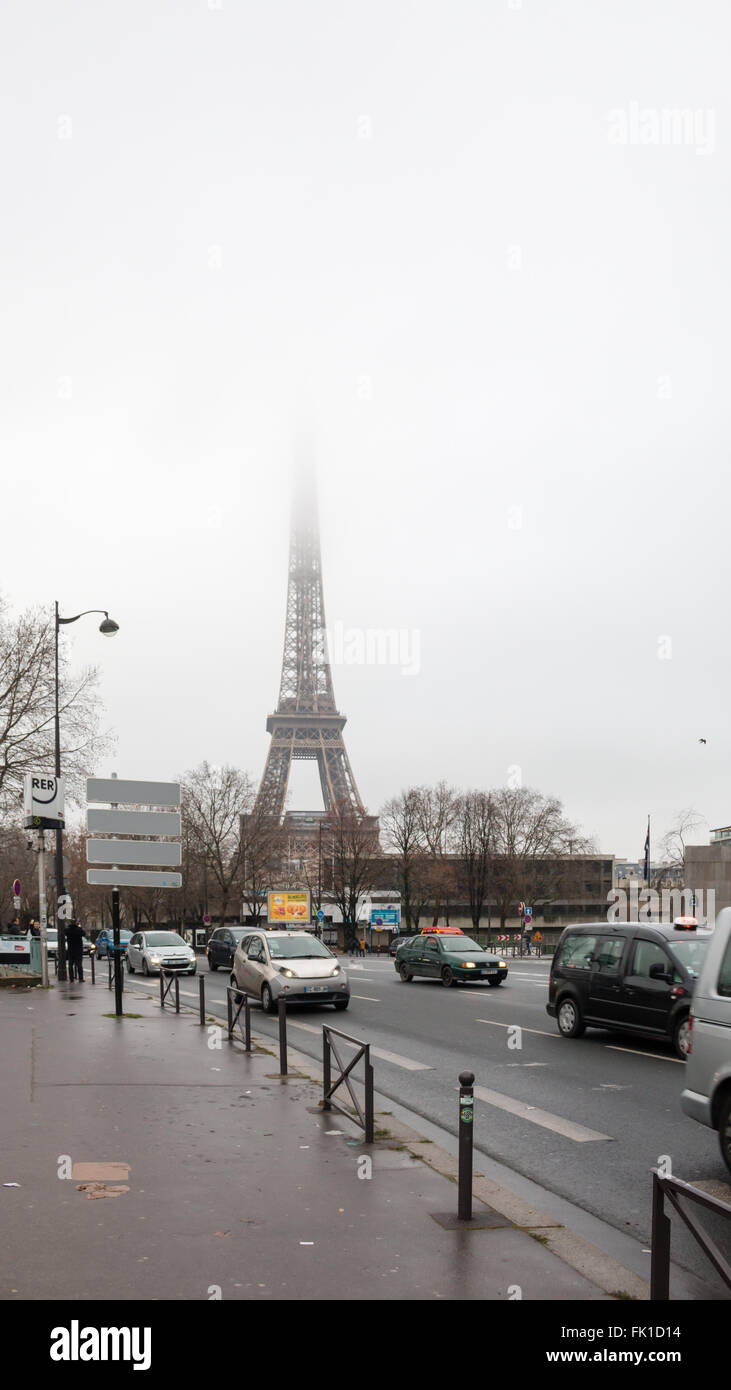 Busy street in Paris on a foggy January morning. Eiffel Tower on