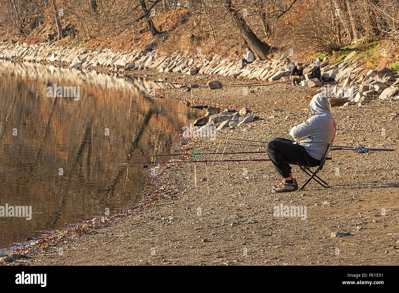 Recreational angler, fisherman, on the bank of the small pond. Relaxation or leisure in the city. Stock Photo