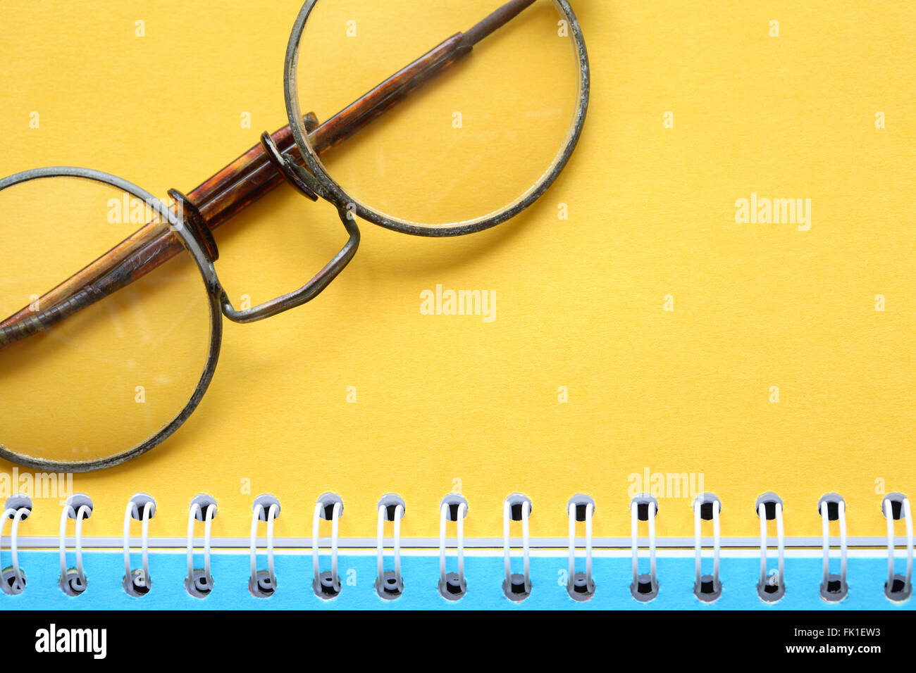 Old vintage spectacles on open notebook with colored pages Stock Photo
