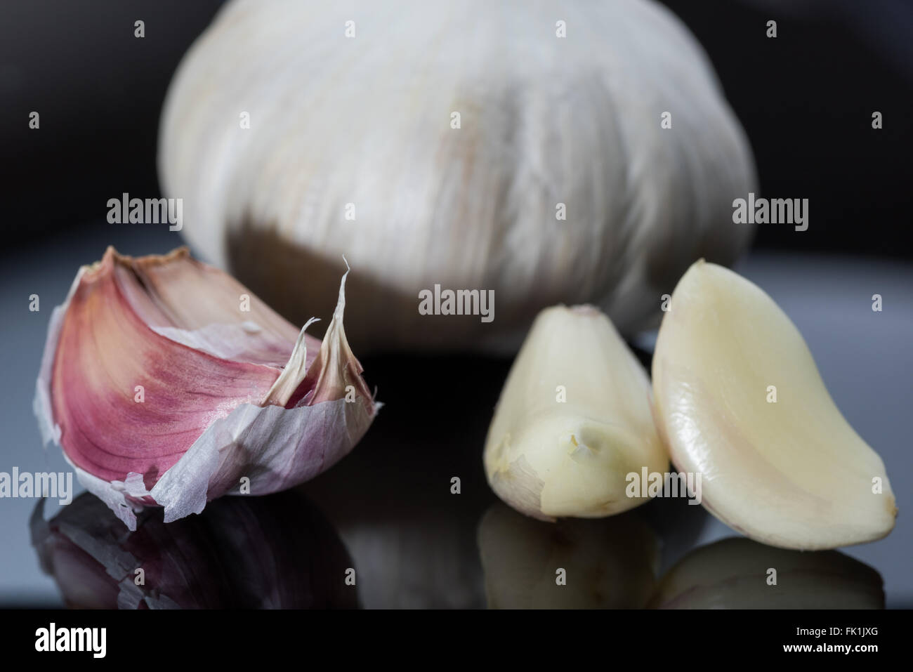 A garlic bulb and clove against a black background Stock Photo Alamy