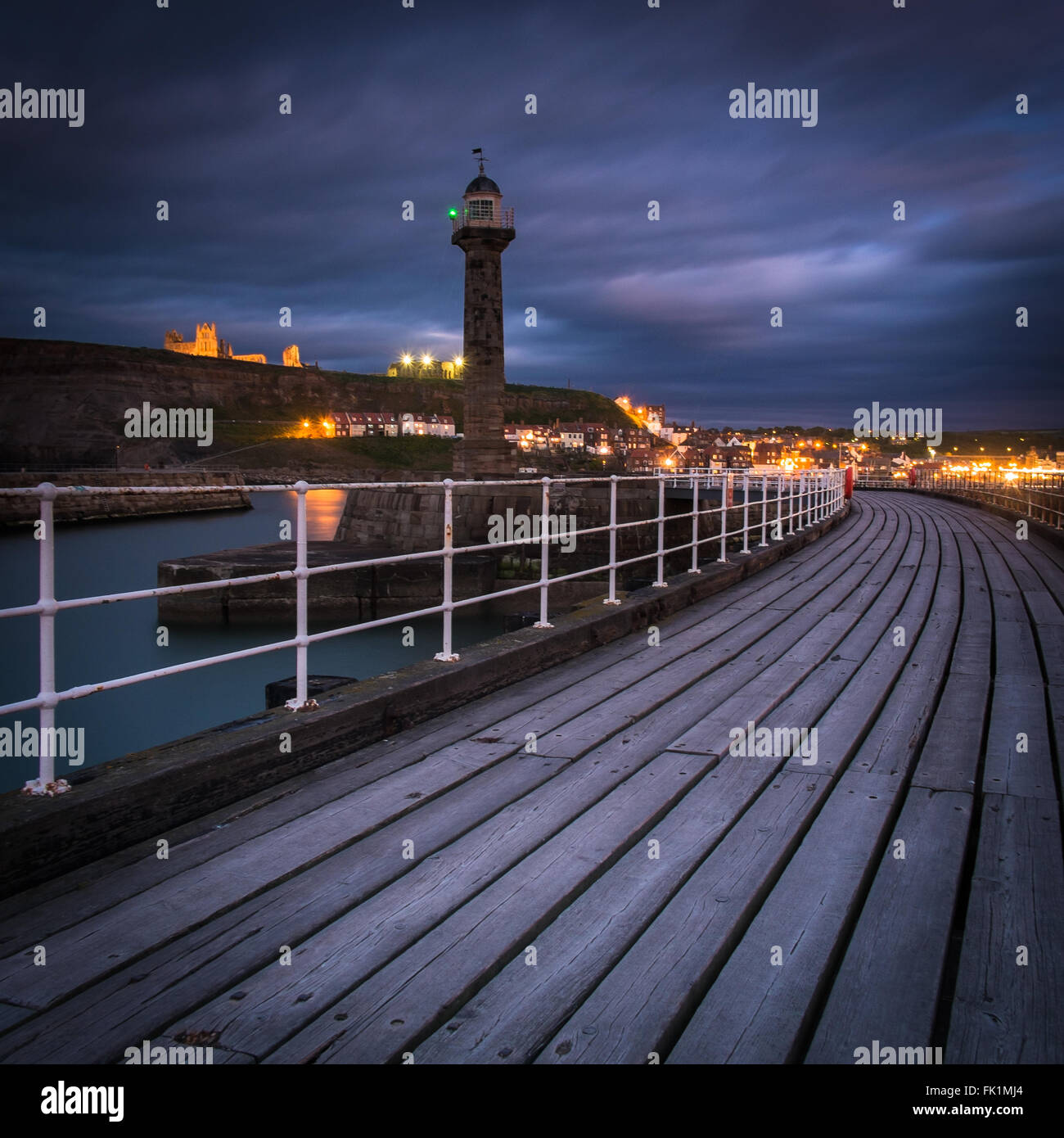 Night time photograph looking back at the lights of Whitby on the North Yorkshire Coast from the west pier extension Stock Photo