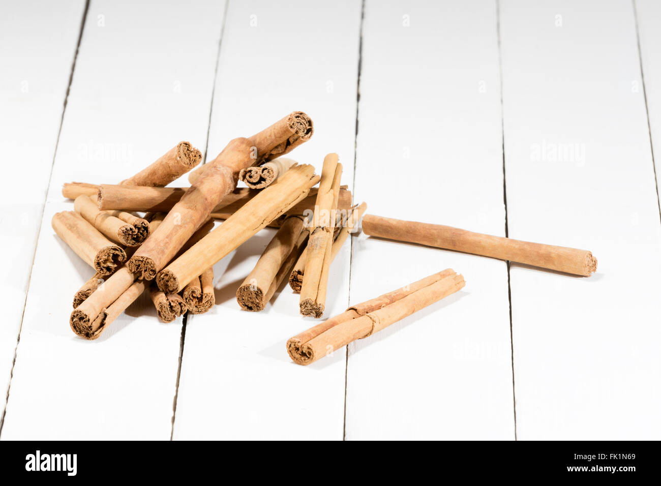 cinnamon sticks pile on a white wooden table Stock Photo