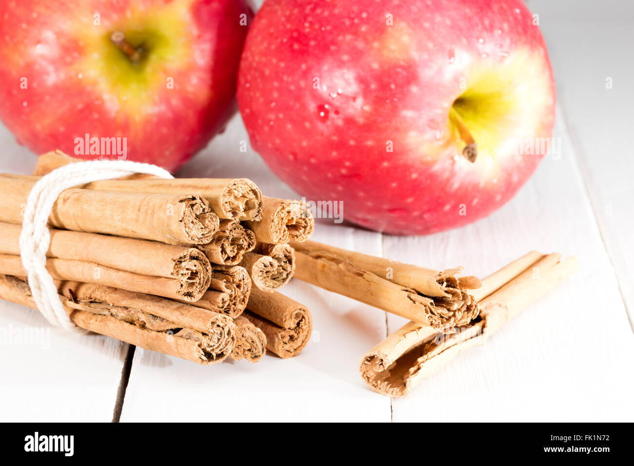cinnamon sticks with apple on kitchen table ready for cooking a recipe Stock Photo