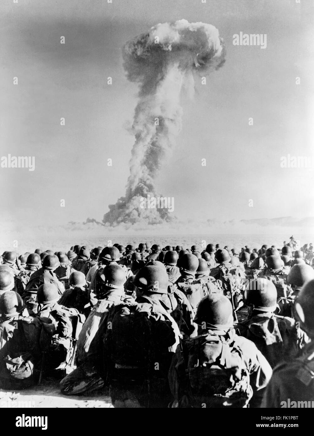 Nuclear Explosion. Troops from 11th AB Division in front of a  mushroom cloud from a nuclear test explosion at Frenchman Flat, Nevada National Security Site, Nevada, USA in November 1951. Stock Photo