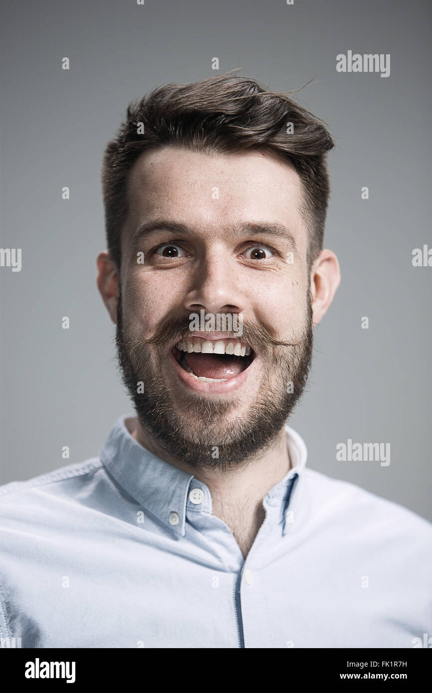 The young happy man looking at camera on gray Stock Photo - Alamy