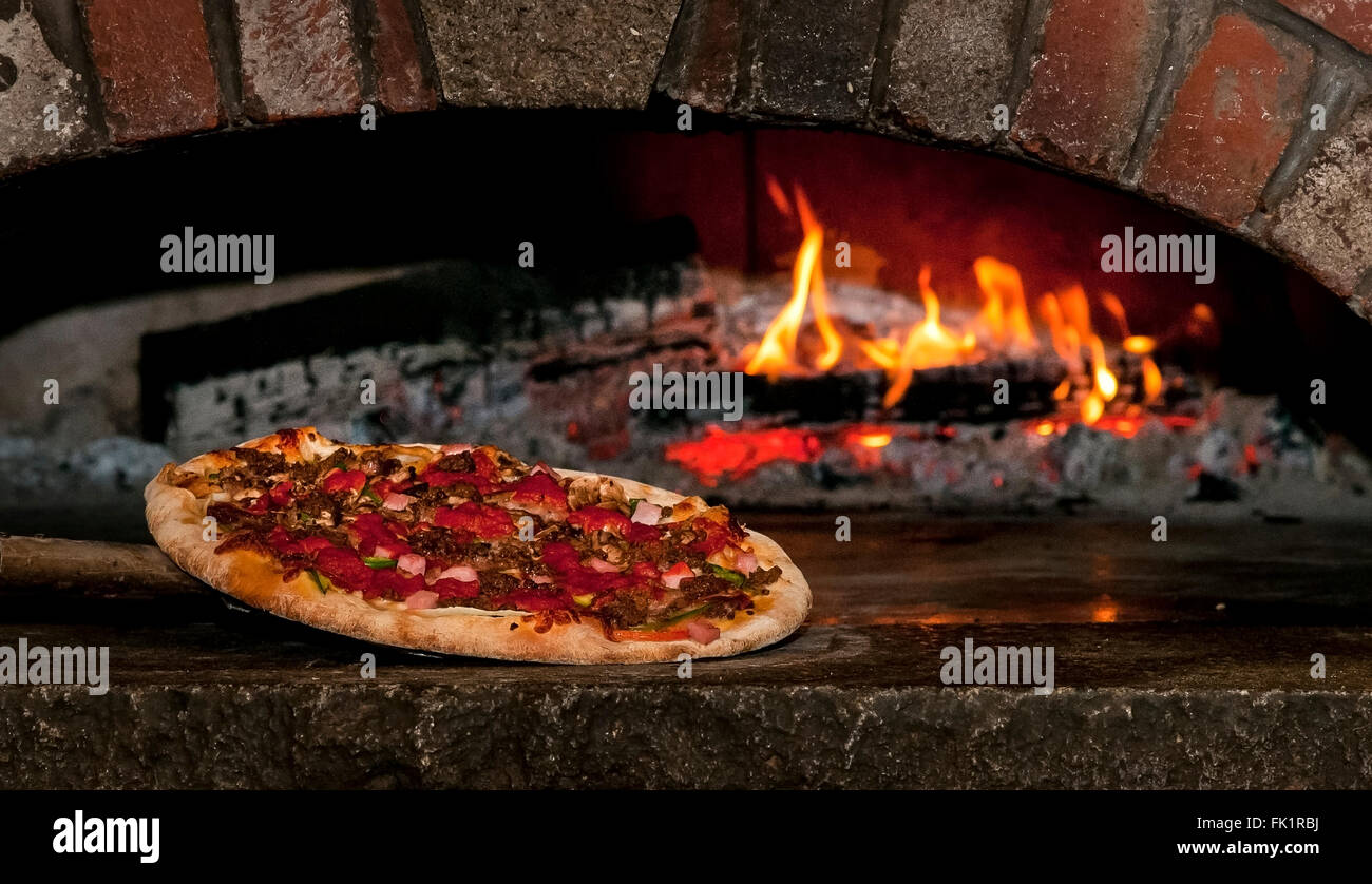 Old fashioned brick oven pizza with the works is ready to eat in New England. Stock Photo