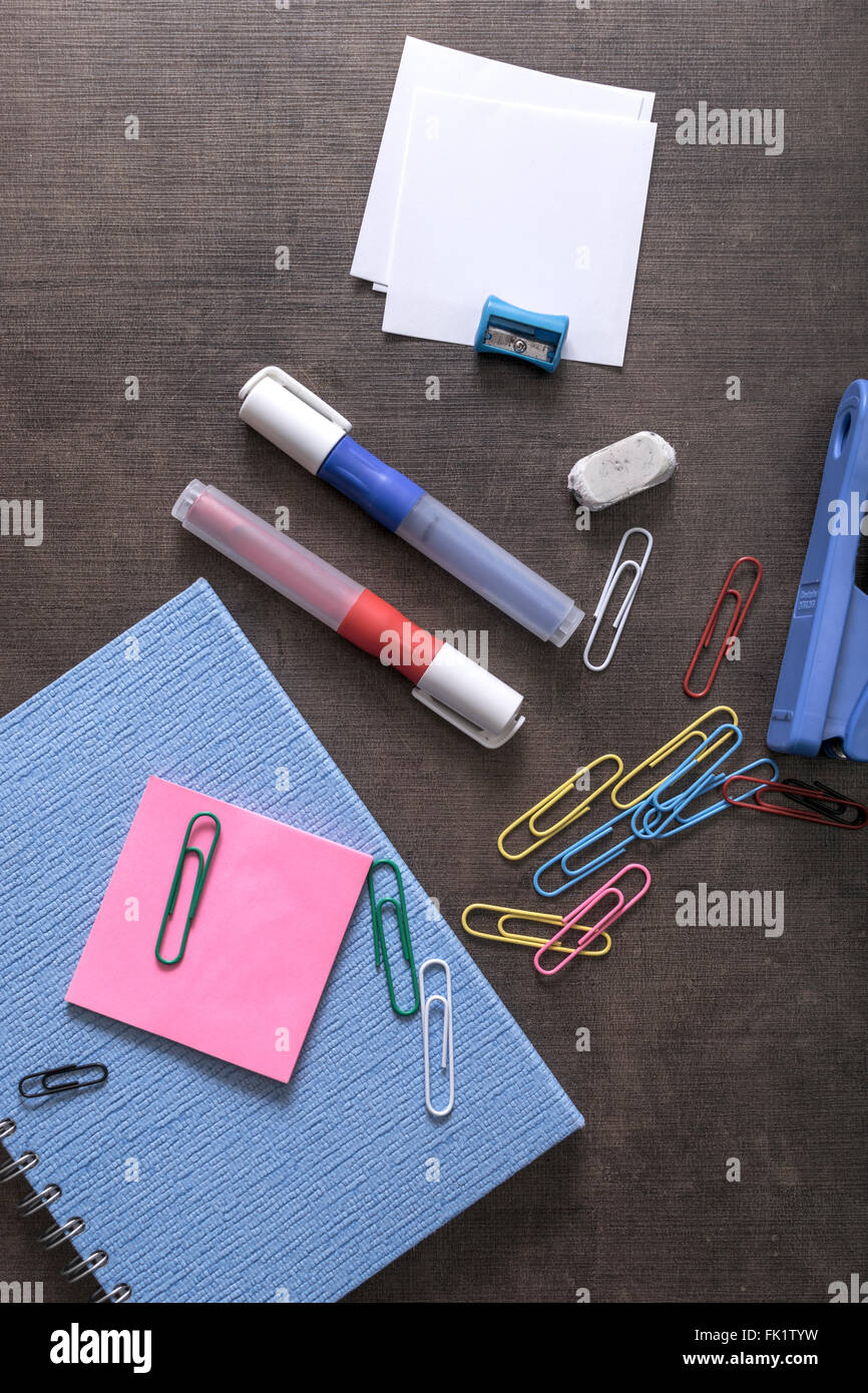 Mix of office supplies on a wooden desk background. View from above ...