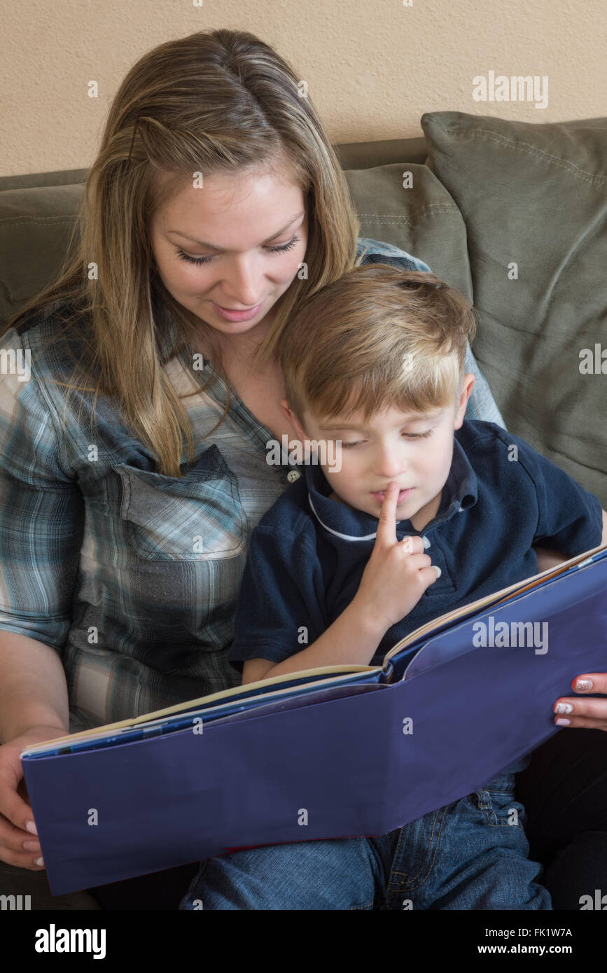 A mother and son enjoy quality time as she reads a book to him. Stock Photo