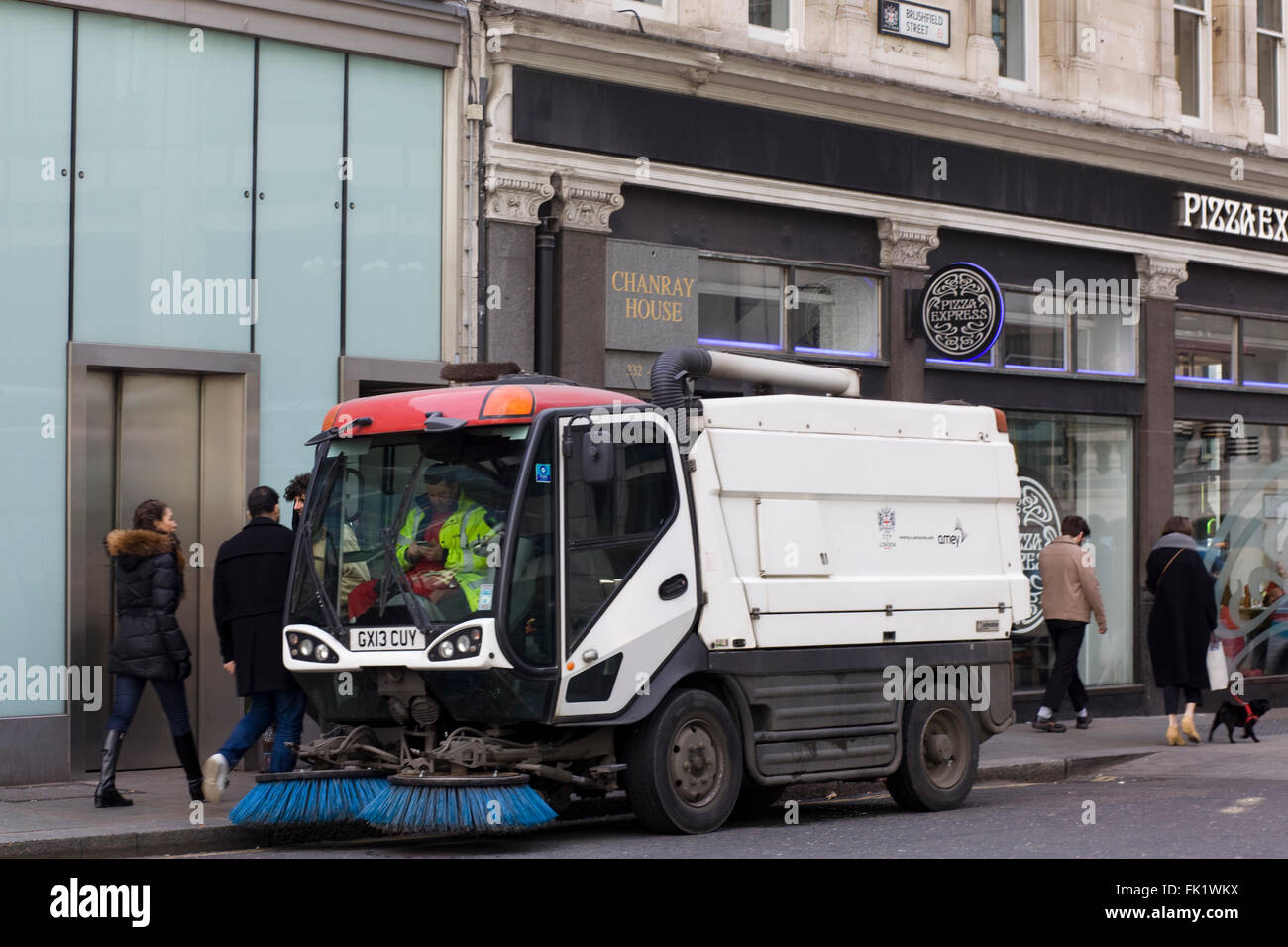 Amey road sweeper with driver using his phone Stock Photo