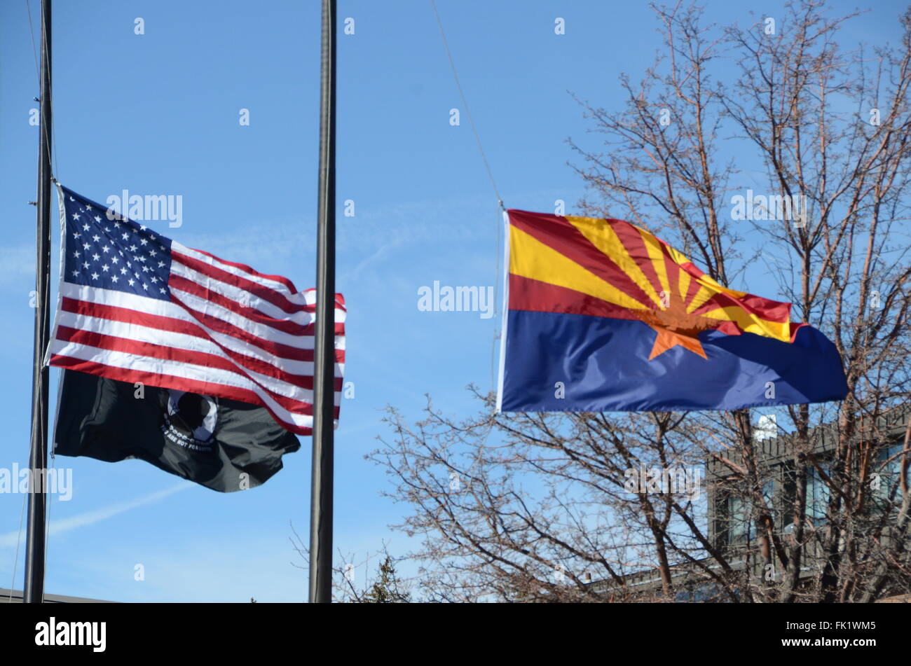 arizona state flag stars and stripes POW/MIA flag flying at half mast