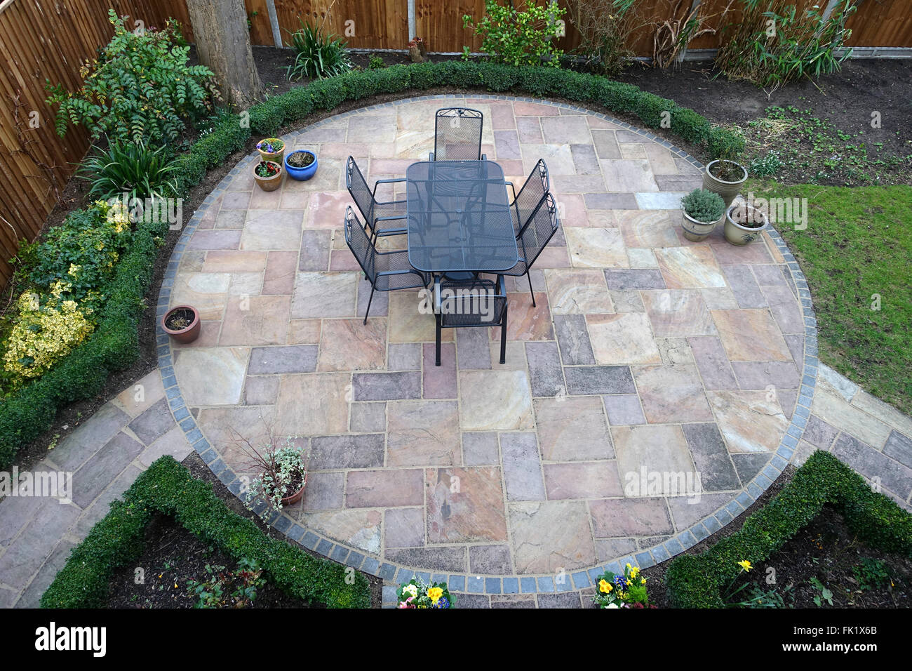 Circular Garden Patio With Metal Table And Chairs In The Middle